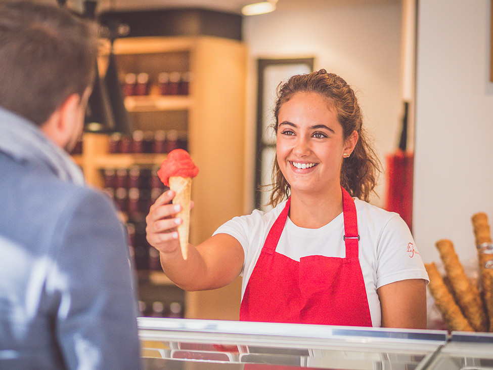 Vendeuse souriante tendant une glace à un client